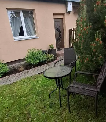a table and two chairs and a table in the grass at Boho House in Šiauliai