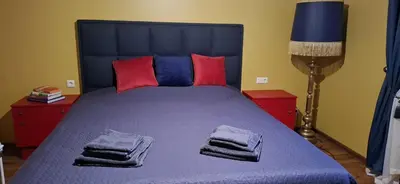 a bedroom with a blue bed with towels on it at Boho House in Šiauliai