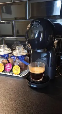 a coffee maker on a counter with a cup of coffee at Boho House in Šiauliai
