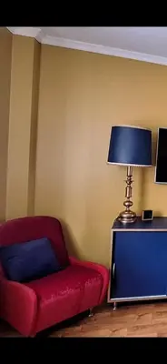 a living room with a red chair and a lamp at Boho House in Šiauliai