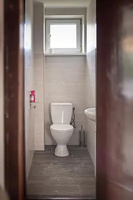 a bathroom with a white toilet and a window at Degučiai ,svečių namai in Šakiai
