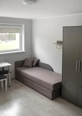 a bedroom with a bed and a window and a table at Degučiai ,svečių namai in Šakiai