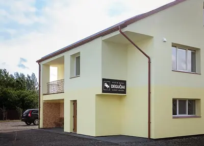 a building with a sign on the side of it at Degučiai ,svečių namai in Šakiai