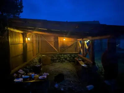 a room with a table in a house at night at Anos Kempingas, Troškūnai in Smėlynė
