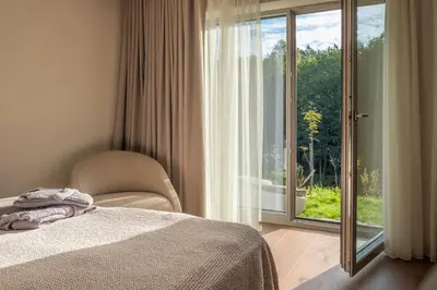 a bedroom with a bed and a sliding glass door at Aukštoji Liškiava in Liškiava