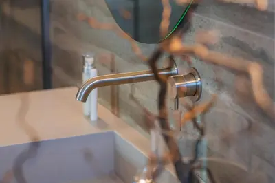 a bathroom sink with a faucet and a mirror at Aukštoji Liškiava in Liškiava