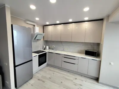 a kitchen with white cabinets and a refrigerator at J&N Hause in Visaginas