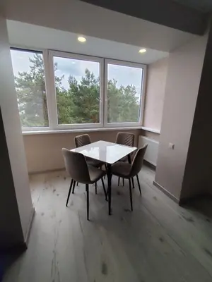 a dining room with a table and chairs and windows at J&N Hause in Visaginas