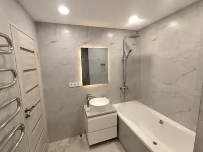 a bathroom with a sink and a tub and a mirror at J&N Hause in Visaginas