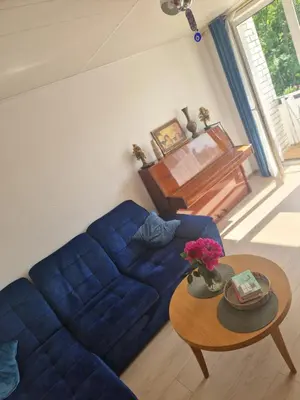 a living room with a blue couch and a table at Pušų lašas apartamentai in Birštonas