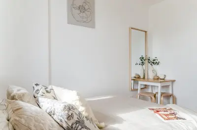 a bedroom with white walls and a bed with pillows at Activity & Relax Studio 5 in Druskininkai