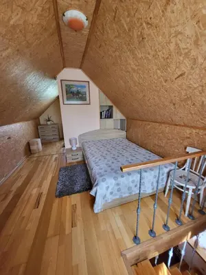 a bedroom with a bed and a wooden floor at Namelis Rugilė in Druskininkai