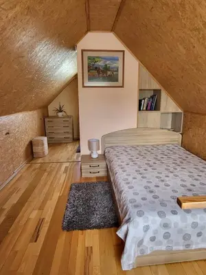 a bedroom with a bed and a wooden floor at Namelis Rugilė in Druskininkai