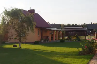 a house with a yard with a green lawn at Namelis Rugilė in Druskininkai