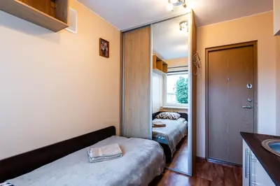 a bedroom with two beds and a mirror at Small Studio Apartment in Kaunas