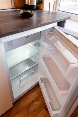 an empty refrigerator with its door open in a kitchen at Small Studio Apartment in Kaunas
