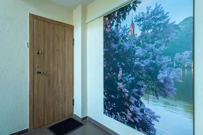 a painting of a tree on a wall next to a door at Park apartment in Druskininkai