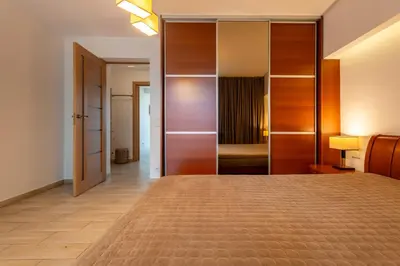 a bedroom with a large bed with a closet at Park apartment in Druskininkai