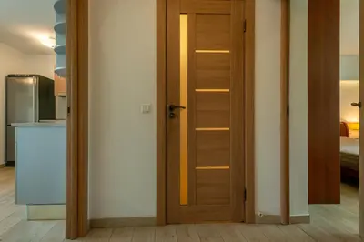 a wooden door in a room with a kitchen at Park apartment in Druskininkai