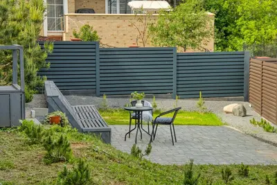 a patio with a table and chairs and a fence at Niwaki Sodai No 1 by URBAN RENT in Vilnius