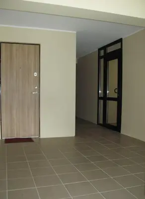an empty room with a door and a tiled floor at Tiny Studio Apartment in Kaunas