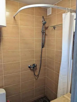 a shower with a shower head in a bathroom at Tiny Studio Apartment in Kaunas