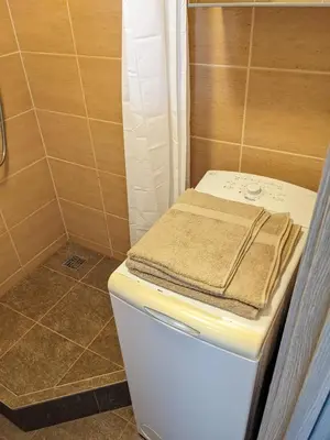 a small bathroom with a toilet and a shower at Tiny Studio Apartment in Kaunas