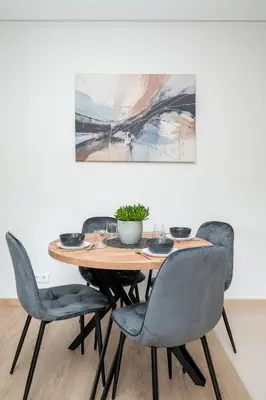 a dining room table with chairs and a painting on the wall at Central Location I Private Garage Parking & Easy Checkin I Cᴏʜᴏsᴛ in Vilnius