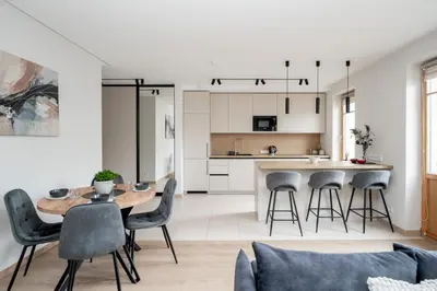 a kitchen and living room with a table and chairs at Central Location I Private Garage Parking & Easy Checkin I Cᴏʜᴏsᴛ in Vilnius