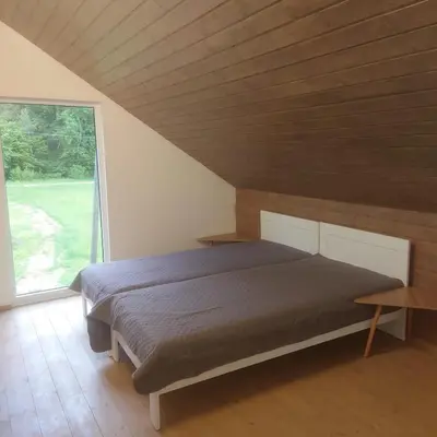 a bedroom with a bed and a large window at Draugų sodyba