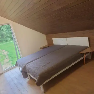 a large bed in a room with a large window at Draugų sodyba