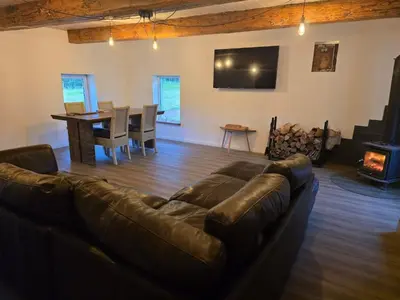 a living room with a leather couch and a table at Draugų sodyba