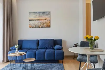 a living room with a blue couch and a table at Niwaki Sodai No 2 by URBAN RENT in Vilnius