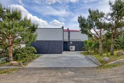 a building with a garage with trees in front of it at Niwaki Sodai No 3 by URBAN RENT in Vilnius