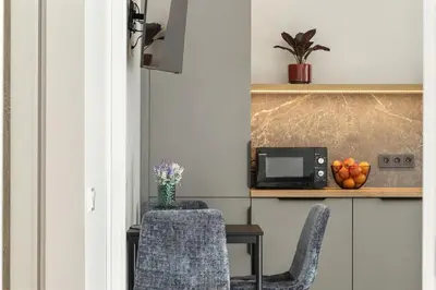 a kitchen with a table and two chairs and a microwave at Niwaki Sodai No 3 by URBAN RENT in Vilnius