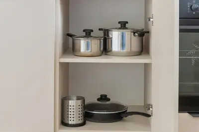 two pots and pans on a shelf in a kitchen at Niwaki Sodai No 3 by URBAN RENT in Vilnius