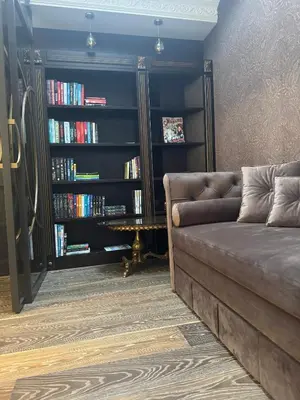a living room with a couch and a book shelf with books at Spacious Townhouse in The Heart of Vilnius Old Town in Vilnius