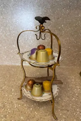 a tea stand with cups and a bird on top at Spacious Townhouse in The Heart of Vilnius Old Town in Vilnius