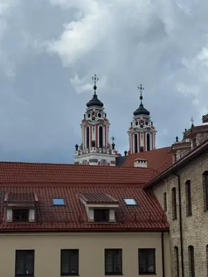 a building with a red roof and two towers at Spacious Townhouse in The Heart of Vilnius Old Town in Vilnius