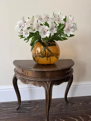 a vase of flowers sitting on a table at Spacious Townhouse in The Heart of Vilnius Old Town in Vilnius