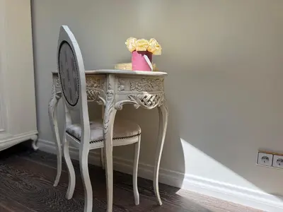 a table with a chair and a vase on it at Spacious Townhouse in The Heart of Vilnius Old Town in Vilnius