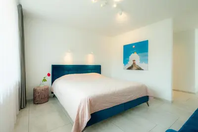 a bedroom with a large bed in a white room at Ice apartment in Druskininkai