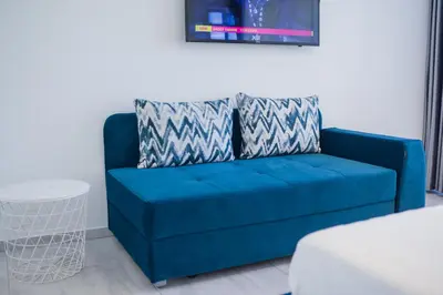 a blue couch sitting in a living room at Ice apartment in Druskininkai