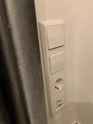 a white electrical box in a bathroom next to a curtain at Ice apartment in Druskininkai