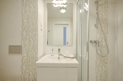a white bathroom with a sink and a shower at Ice apartment in Druskininkai
