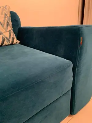 a blue couch sitting in a living room at Ice apartment in Druskininkai
