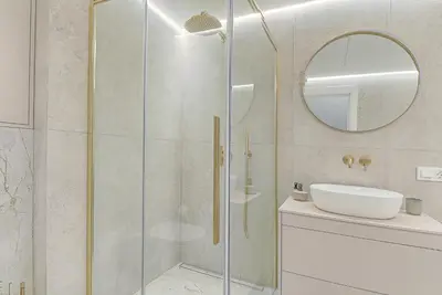 a bathroom with a shower with a sink and a mirror at Premium apartment x free parking x 24x7 in Vilnius