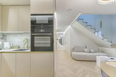 a kitchen with a staircase and a living room at Premium apartment x free parking x 24x7 in Vilnius