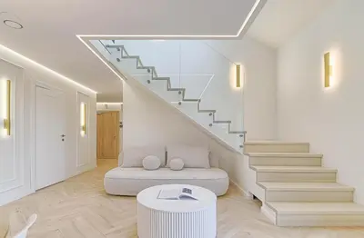 a living room with a staircase with a couch and a stool at Premium apartment x free parking x 24x7 in Vilnius