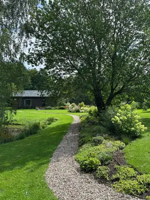 a gravel path with a tree in a yard at Pramogų namelis